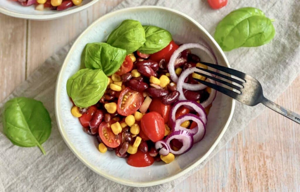 Bohnensalat mit Mais und Tomaten in einer Schüssel.