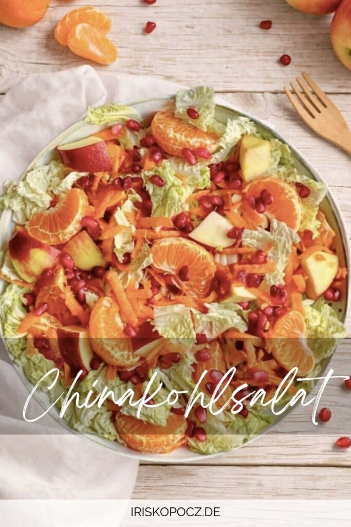 Chinakohlsalat mit Mandarinen, Äpfeln, Karotten und Granatapfelkernen in einer Schüssel-Pin.