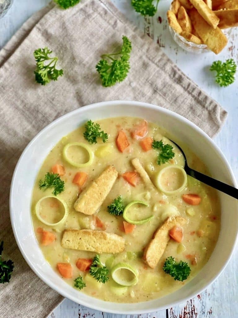 Vegane Kartoffelsuppe mit Räuchertofu und Gemüse in einem Suppenteller.