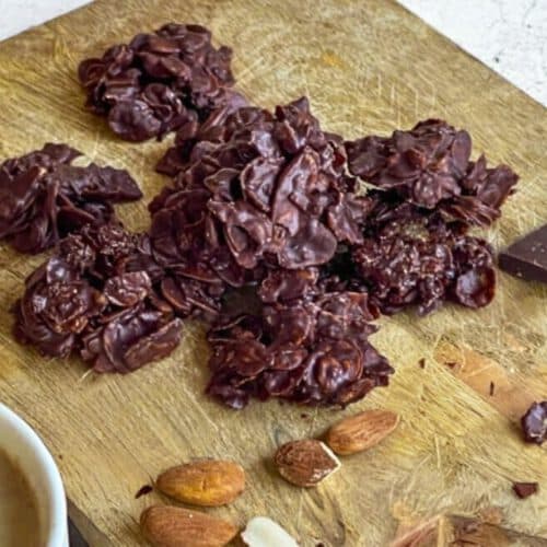 Vegane Choco Crossies mit Mandeln und Schokolade auf einem Holzbrett.