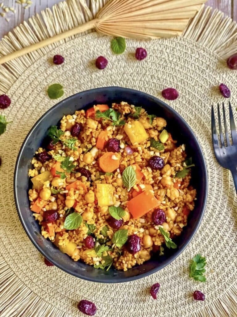 Veganer Bulgursalat mit Gemüse und Kräutern in einer Schüssel.