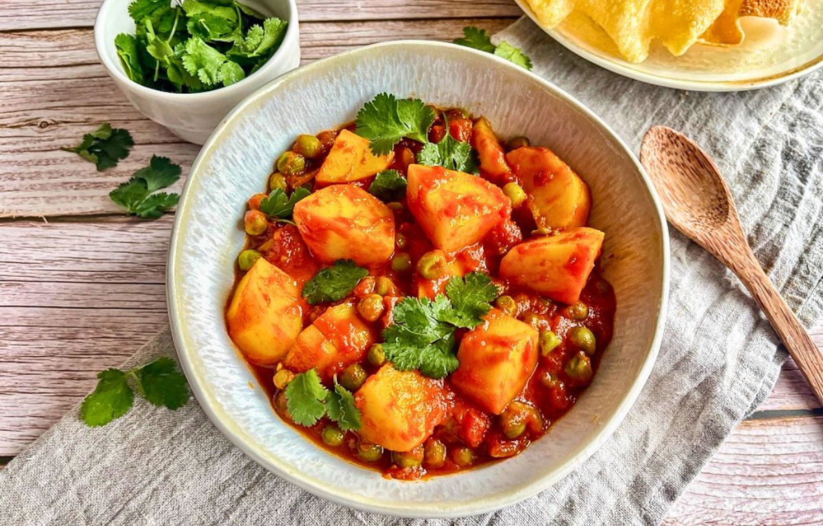 Veganes Aloo Matar: Ein herzhaftes indisches Curry mit Kartoffeln und Erbsen auf einem Teller.