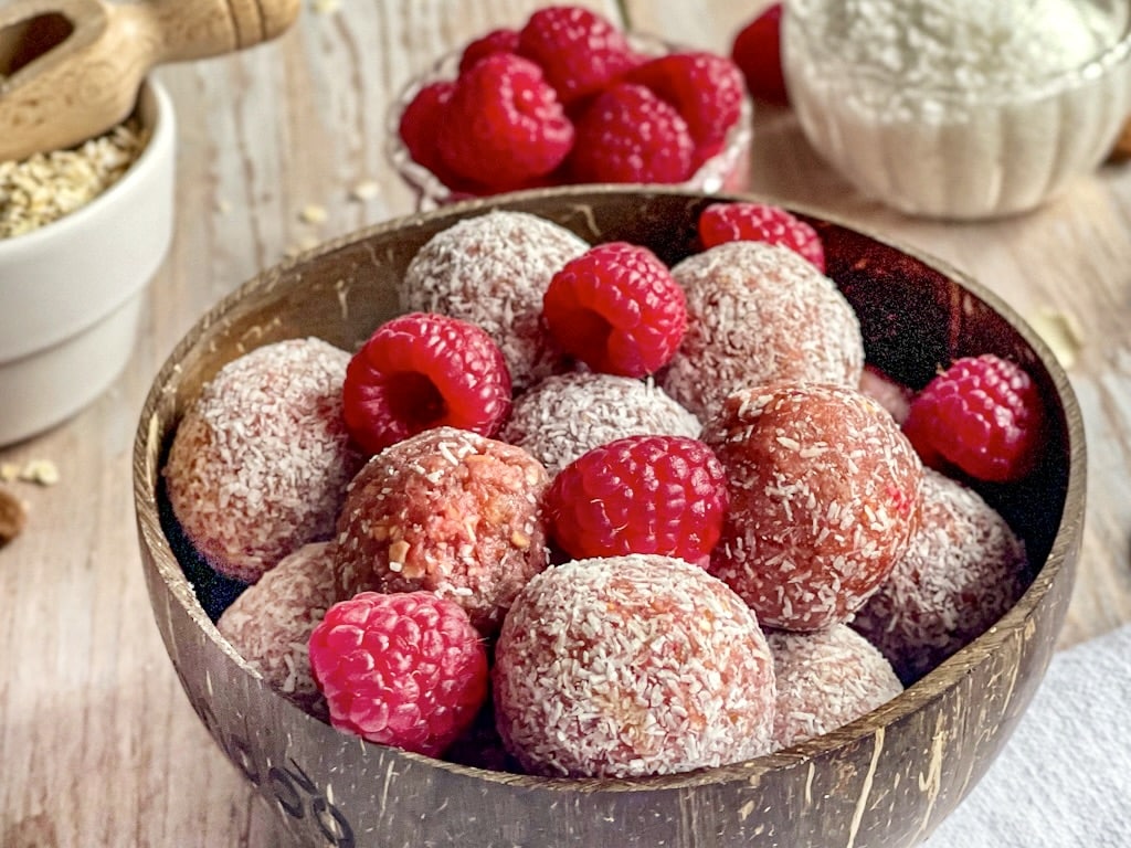 Energy Balls mit Beeren und Kokosraspeln in einer Schüssel.