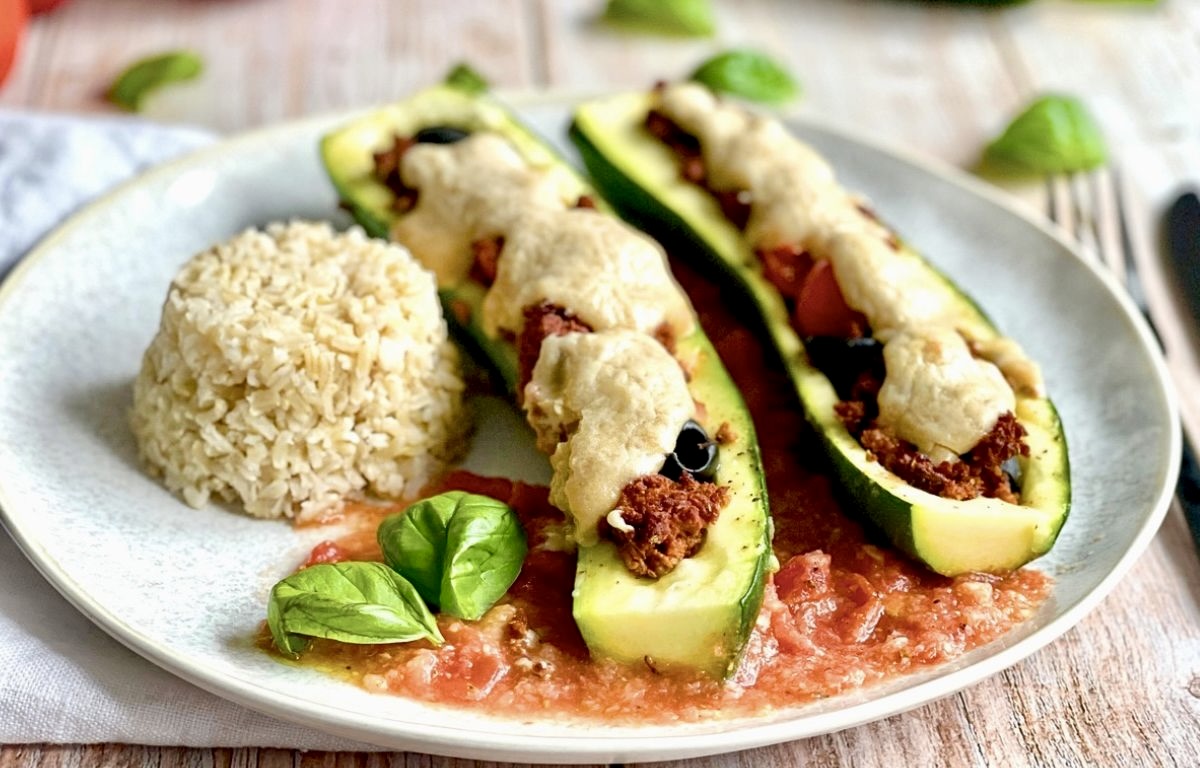 Vegane gefüllte Zucchini mit Reis auf einem Teller.