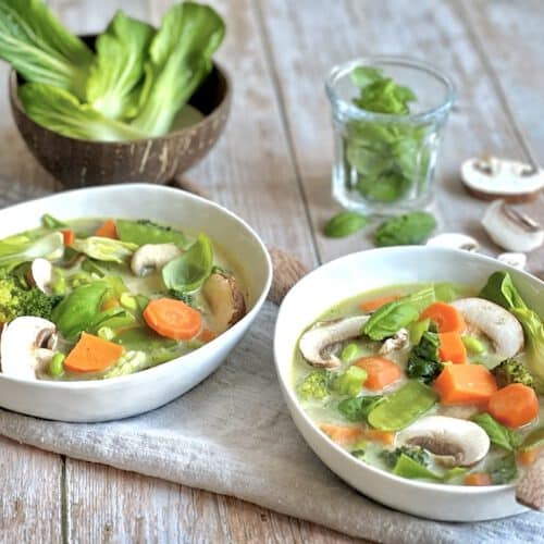 Vegane Gemüse-Kokos-Suppe in zwei Tellern.