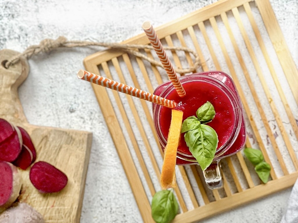 Fruchtig leckerer Rote-Bete-Smoothie in deinem Glas auf einem Holzbrett.