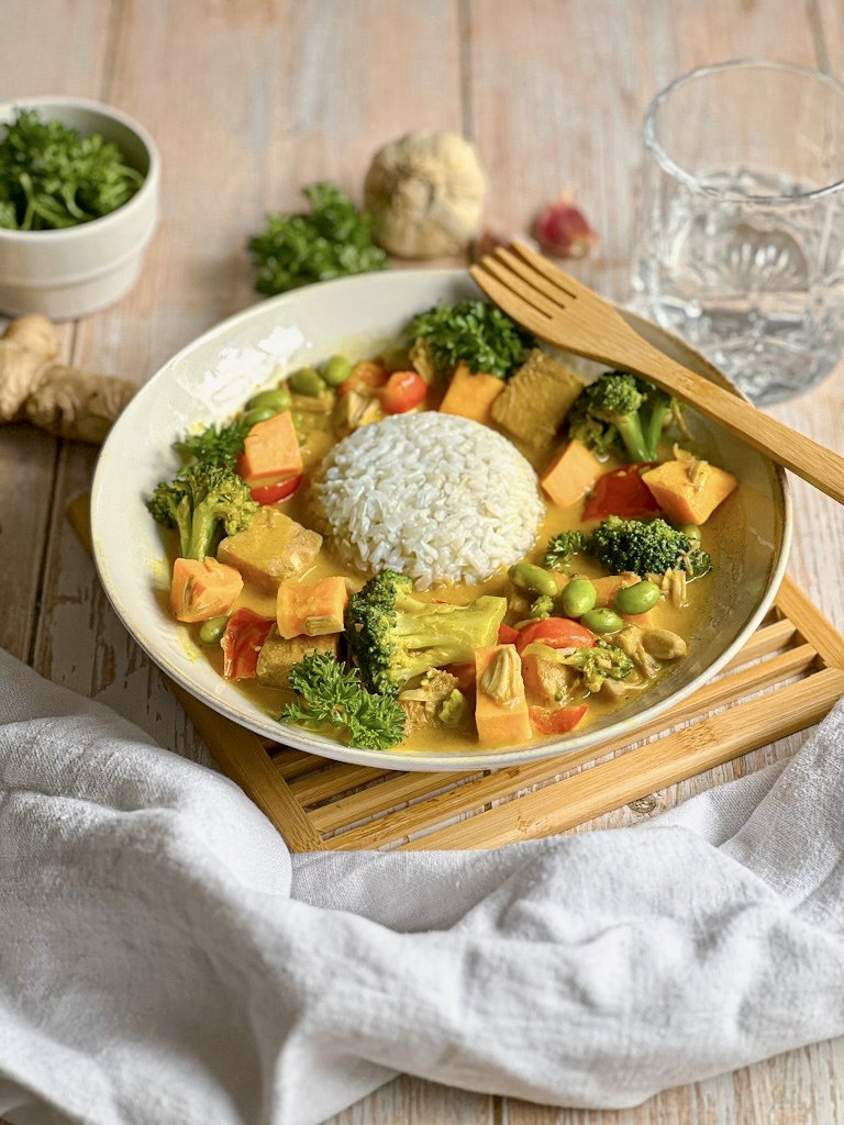 Leckeres veganes Jackfruit-Gemüse-Curry mit Reis auf einem Teller.