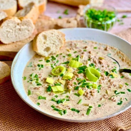 Vegane Käse-Lauch-Suppe mit Hack und Baguettescheiben.