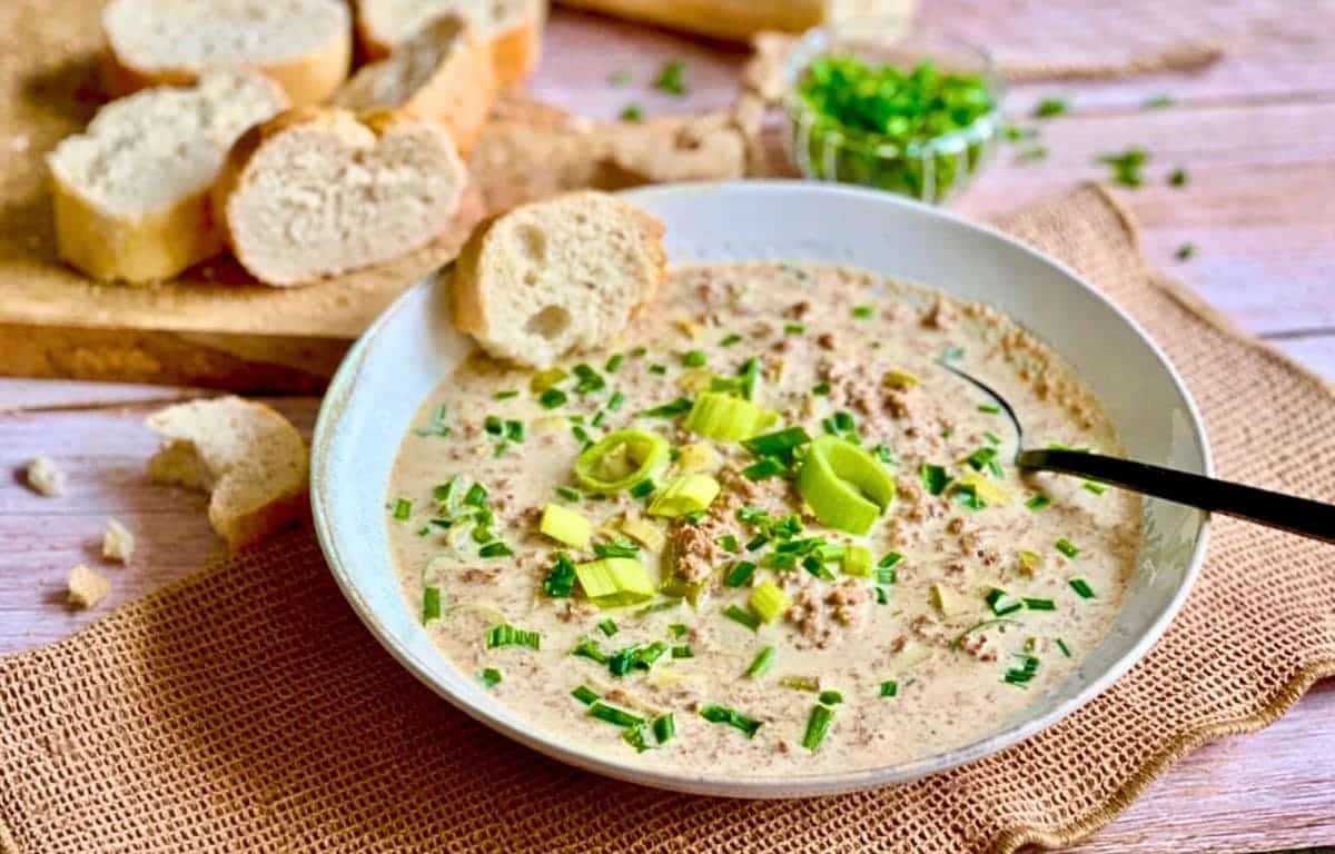 Vegane Käse-Lauch-Suppe mit Hack und Baguettescheiben.