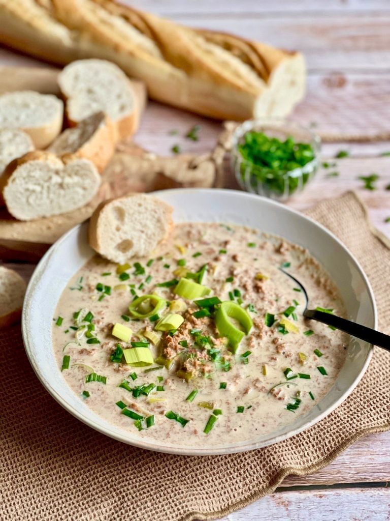 Vegane Käse-Lauch-Suppe mit Hack und Baguettescheiben.