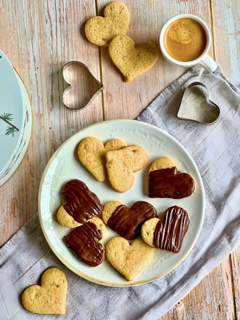 Vegane Ingwer-Zitronen-Kekse, teilweise mit Schokoladentopping, auf einem Teller.