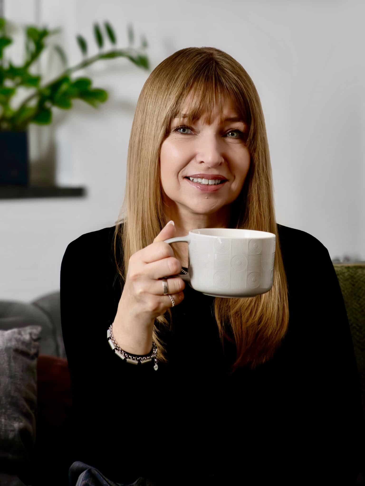 Iris mit einer Tasse in der Hand.