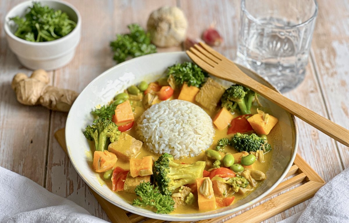 Leckeres veganes Jackfruit-Gemüse-Curry mit Reis auf einem Teller.