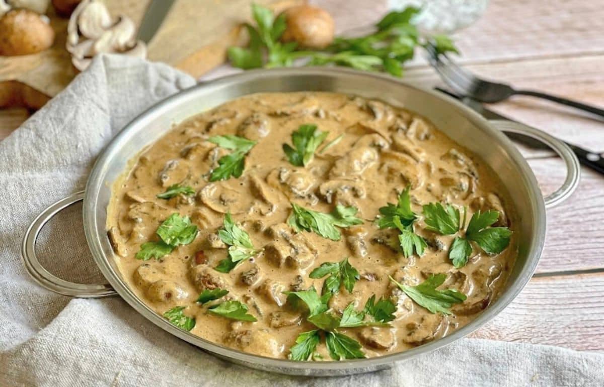 Vegane Rahmchampignons in einer Pfanne auf einem Tisch.
