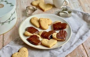 Vegane Ingwer-Zitronen-Kekse, teilweise mit Schokoladentopping, auf einem Teller