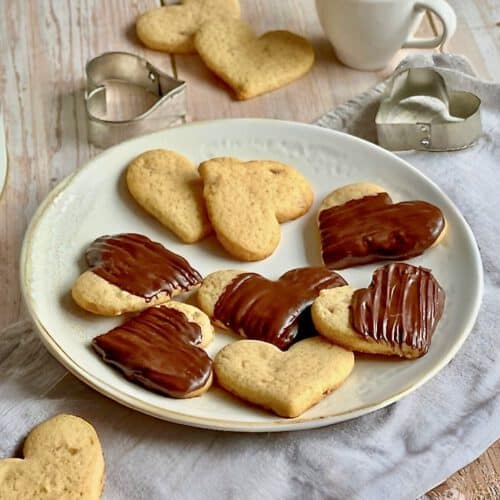 Vegane Ingwer-Zitronen-Kekse, teilweise mit Schokoladentopping, auf einem Teller