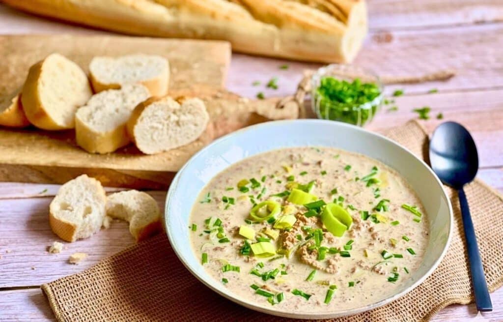Vegane Käse-Lauch-Suppe mit Hack und Baguettescheiben.