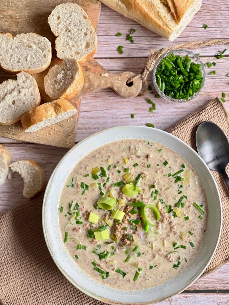 Vegane Käse-Lauch-Suppe mit Hack und Baguettescheiben.