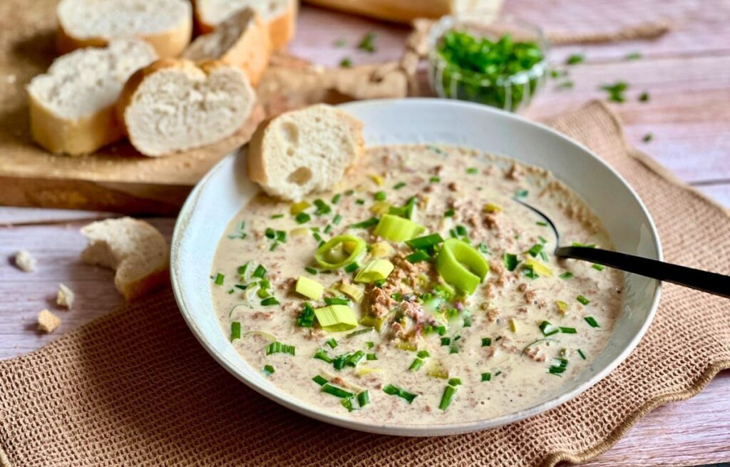 Vegane Käse-Lauch-Suppe mit Hack und Baguettescheiben.