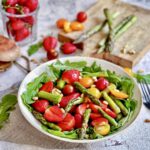 Gesunder und leckerer Spargelsalat mit Erdbeeren & Rucola auf einem Teller.