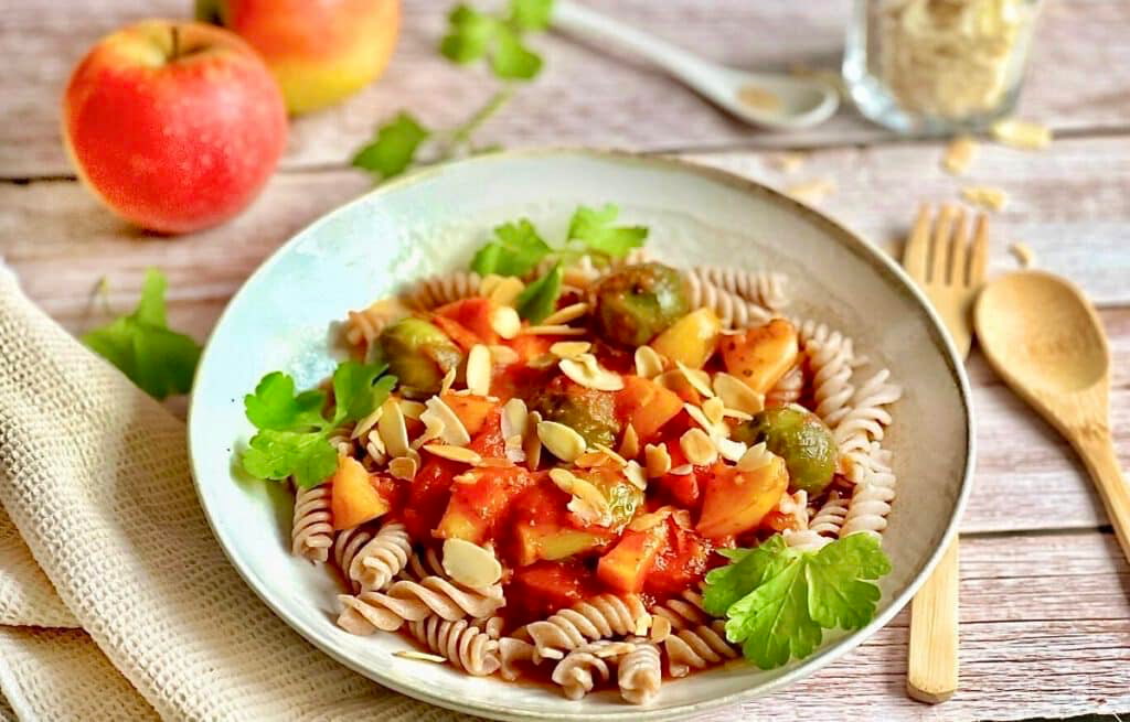Vegane Pasta mit Rosenkohl in Tomaten-Apfel-Soße auf einem Teller.