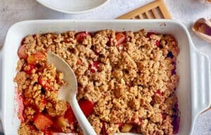 Veganer und glutenfreier Rhabarber-Erdbeercrumble in einer Auflaufform.