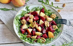 Rote-Bete-Salat mit Apfel, Rucola und Walnüssen auf einem Teller.