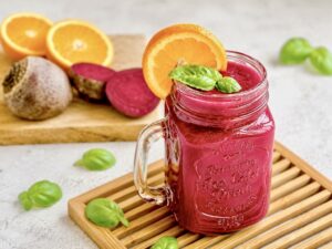 Fruchtig leckerer Rote-Bete-Smoothie in deinem Glas auf einem Holzbrett.