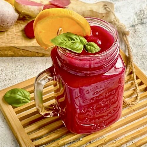 Fruchtig leckerer Rote-Bete-Smoothie in deinem Glas auf einem Holzbrett.