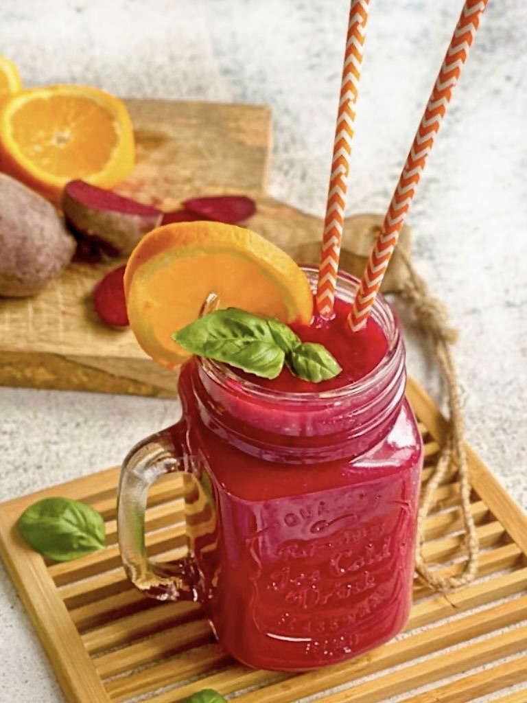 Fruchtig leckerer Rote-Bete-Smoothie in deinem Glas auf einem Holzbrett.