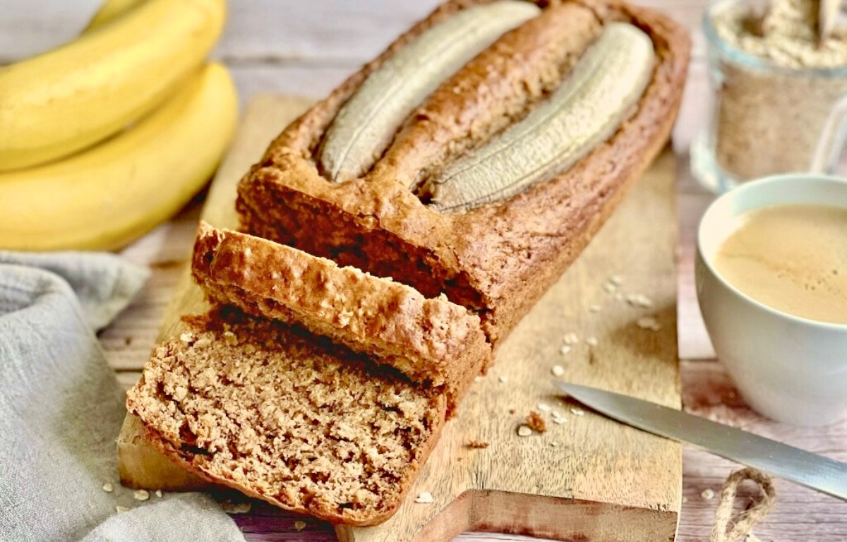 Veganes Bananenbrot mit Haferflocken auf einem Holzbrett.