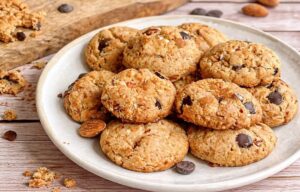 Vegane Erdnussbutter-Kekse mit Mandeln und Schokolade auf einem Teller.