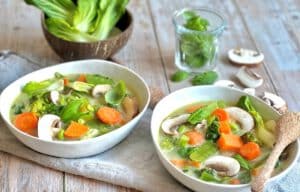 Vegane Gemüse-Kokos-Suppe in zwei Tellern.