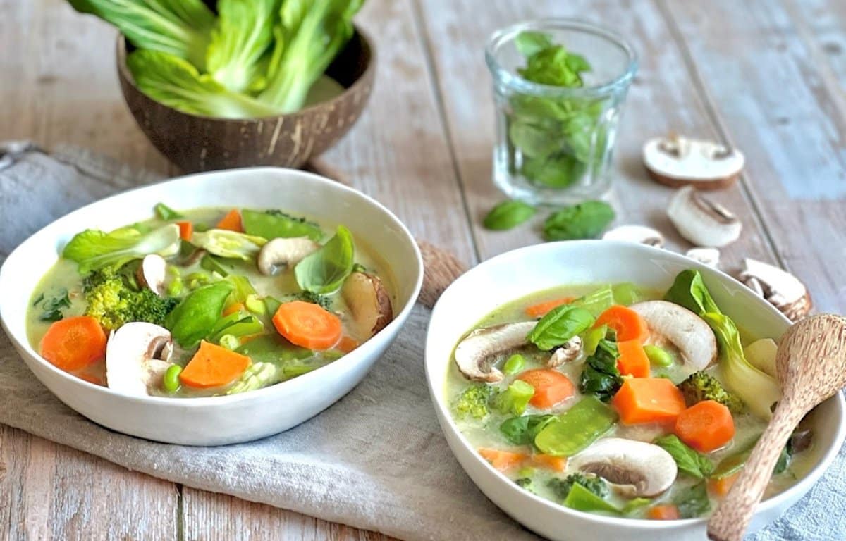 Vegane Gemüse-Kokos-Suppe in zwei Tellern.