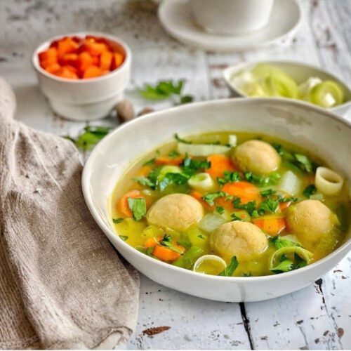 Vegane Gemüsesuppe mit Grießklößchen/Grießnockerln in einem Suppenteller.