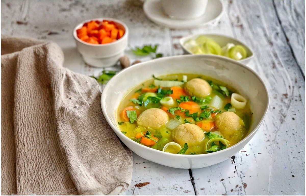 Vegane Gemüsesuppe mit Grießklößchen/Grießnockerln in einem Suppenteller.