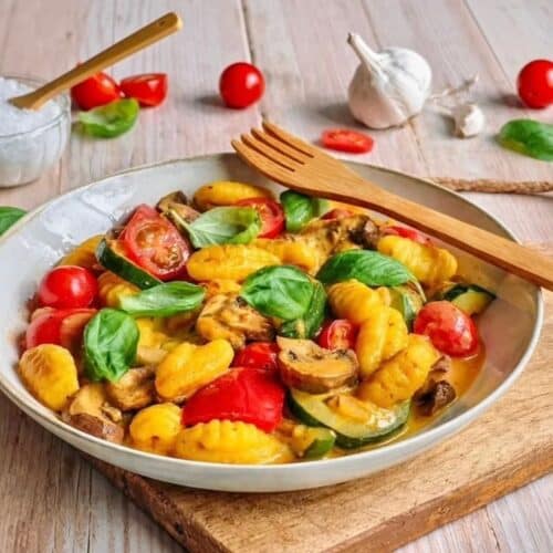 Vegane Gnocchi-Gemüsepfanne mit Basilikum auf einem Teller.