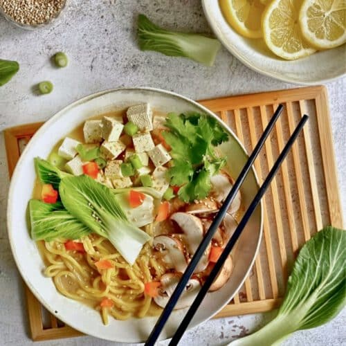 Leckere vegane Misosuppe auf einem Teller mit Stäbchen.