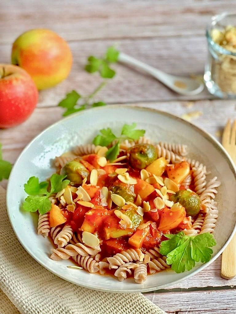 Vegane Pasta mit Rosenkohl in Tomaten-Apfel-Soße auf einem Teller.