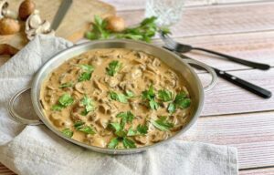 Vegane Rahmchampignons in einer Pfanne auf einem Tisch.