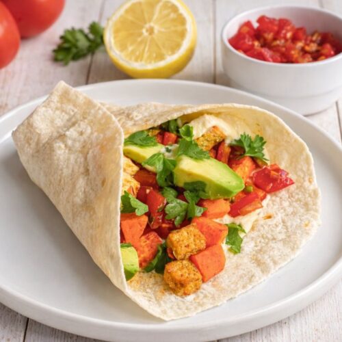 Vegane Wraps mit Süßkartoffelln und Tofu auf einem Teller.