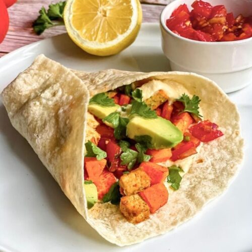 Vegane Wraps mit Süßkartoffelln und Tofu auf einem Teller.