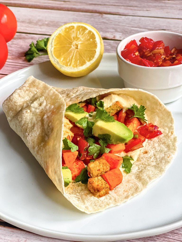 Vegane Wraps mit Süßkartoffelln und Tofu auf einem Teller.