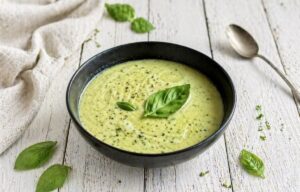 Vegane Zucchinisuppe mit Basilikum in einem Suppenteller.