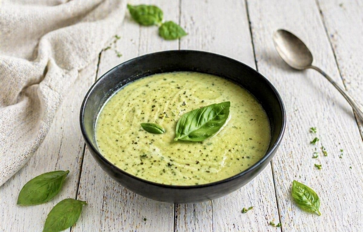 Vegane Zucchinisuppe mit Basilikum in einem Suppenteller.