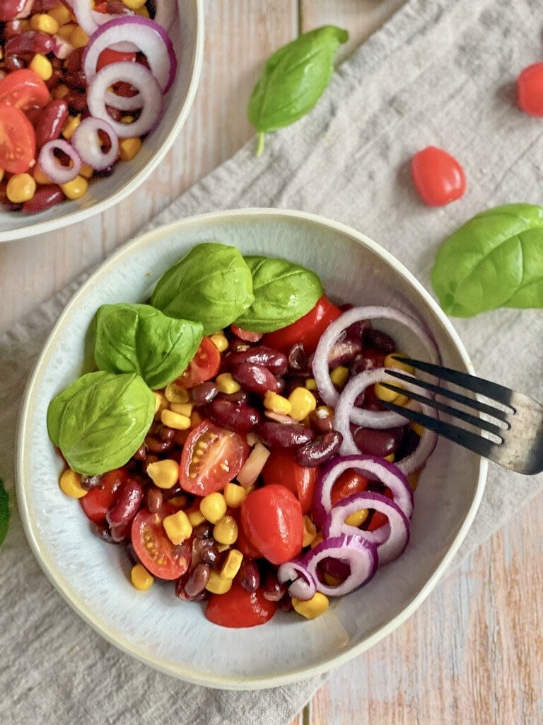 Bohnensalat mit Mais und Tomaten in einer Schüssel.