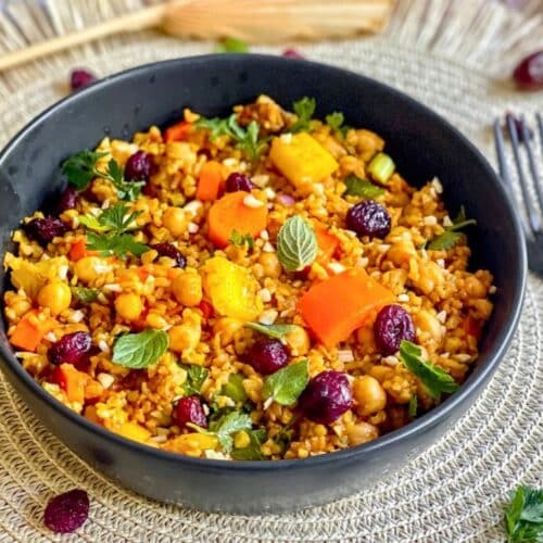 Veganer Bulgursalat mit Gemüse und Kräutern in einer Schüssel.