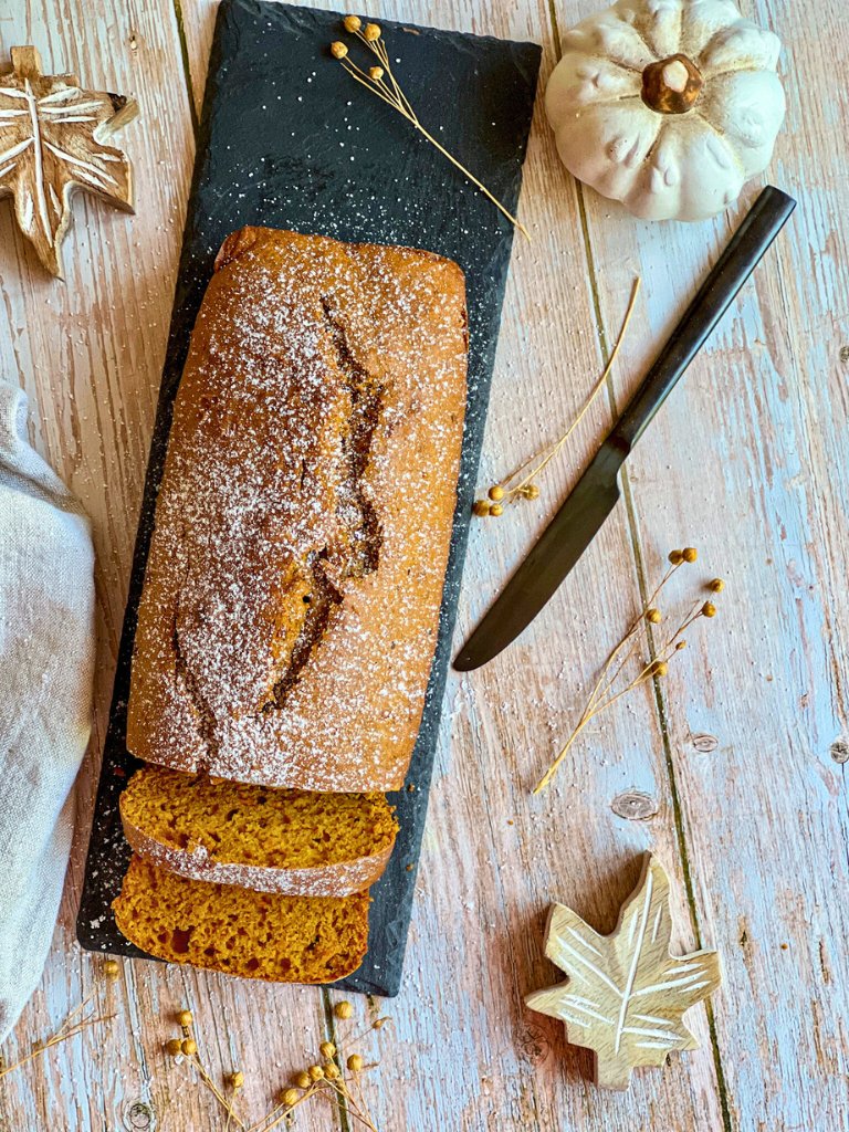 Veganer Kürbiskuchen auf einer schwarzen Platte.